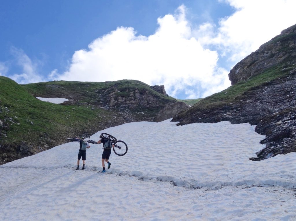 Two mountain bikers hiking the bike